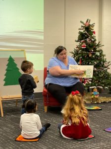 Miss Catie reading Spot's First Christmas by Eric Hill