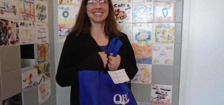 Weekly Winner of the Sedalia Adult Winter Read show off her bag of books prize