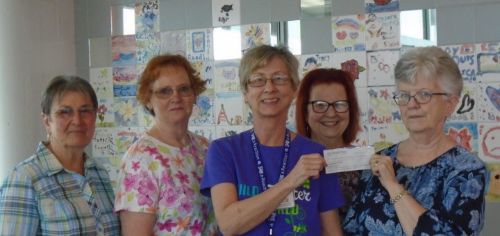 5 women displaying a donation check.