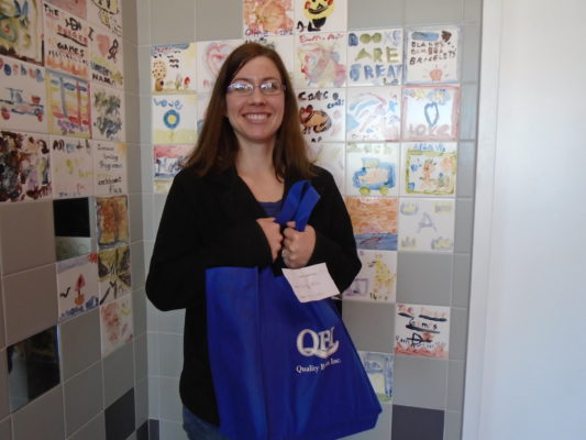 Weekly Winner of the Sedalia Adult Winter Read show off her bag of books prize