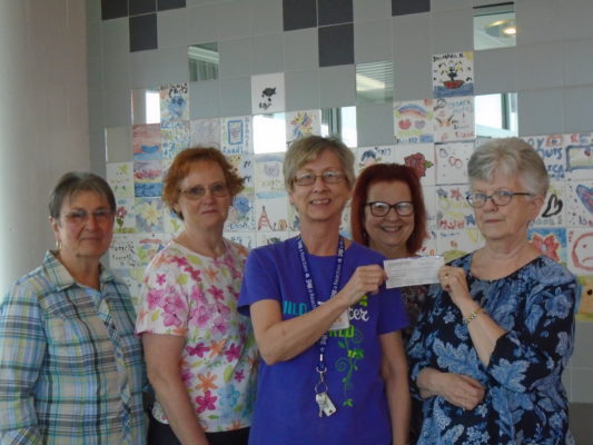 5 women displaying a donation check.
