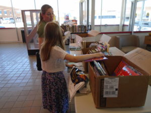 woman and daughter choosing a book from boxes