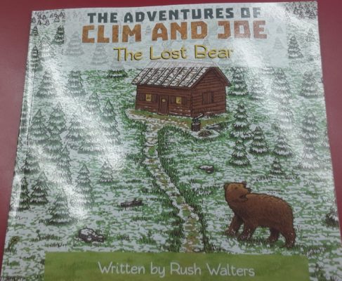 Book Cover with a cabin and a bear looking at cabin